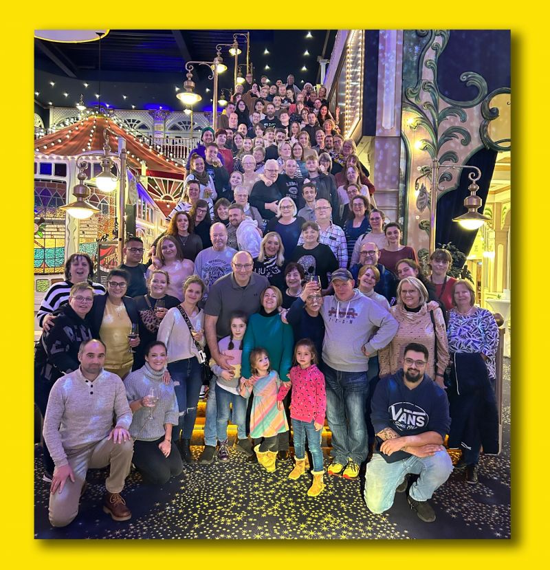 Gruppenfoto EDEKA Weinle Fröhliche Mitarbeiter von EDEKA Weinle bei einer Weihnachtsfeier im Europark auf einer Treppe