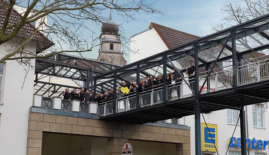 Mitarbeiter ders E Center Weinle in Herrenberg winken vom Fußgängersteg