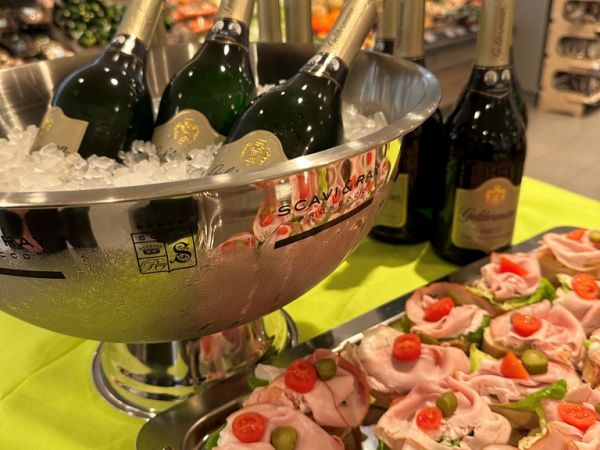 Foto zum Kundenfrühstück mit einem Sektkühler mit Eis und 3 Sektflaschen sowie einer Platte mit Canapés